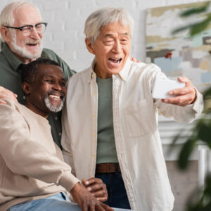 Foto com três homens idosos mostrando habilidade com tecnologia