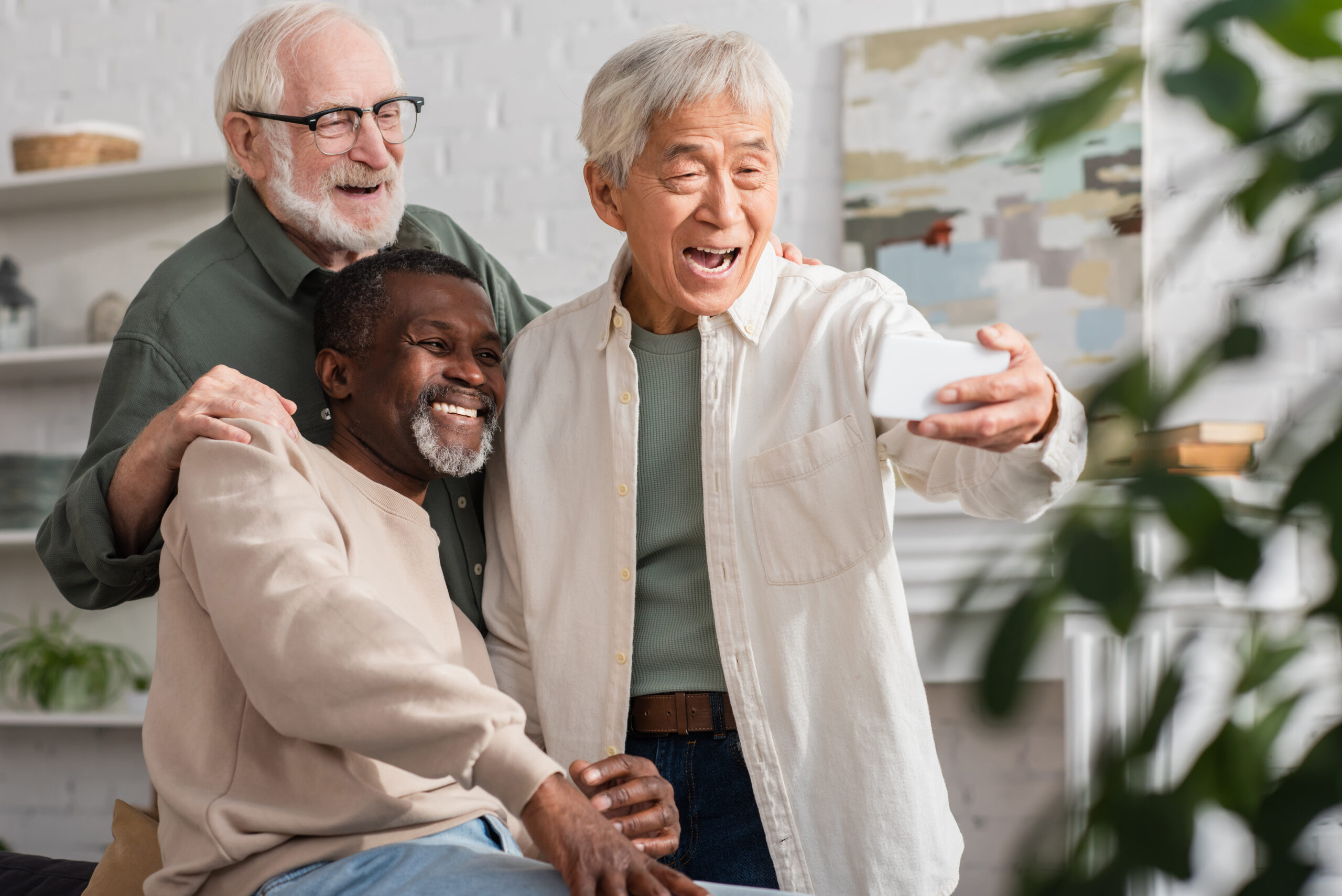 Foto com três homens idosos mostrando habilidade com tecnologia